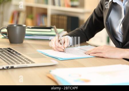 Nahaufnahme der selbstständigen Frau Hände Ausfüllen Checkbox Formular sitzen auf einem Schreibtisch im Homeoffice Stockfoto