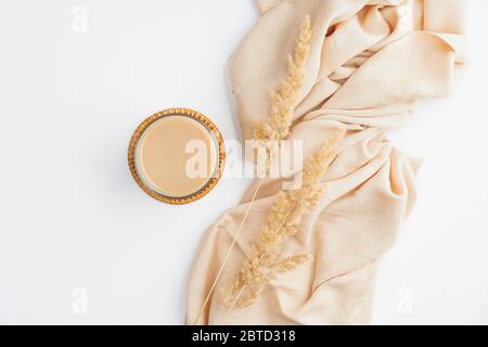 Herbstkomposition mit Tasse Kaffee, beiger Decke und trockenen Blüten auf weißem Tisch. Flach liegend, Draufsicht. Hygge oder Boho Stil, Herbst Konzept Stockfoto
