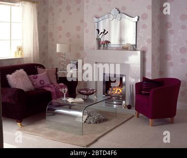 Sofa und Stuhl aus violettem Samt im Wohnzimmer mit Acryltisch Stockfoto