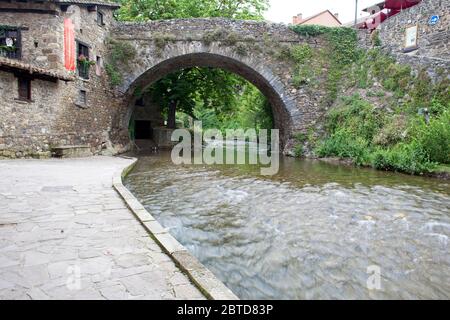 Der Fluss Quiviesa fließt unter einer alten Steinbrücke in Potes, Kantabrien, Spanien. Stockfoto