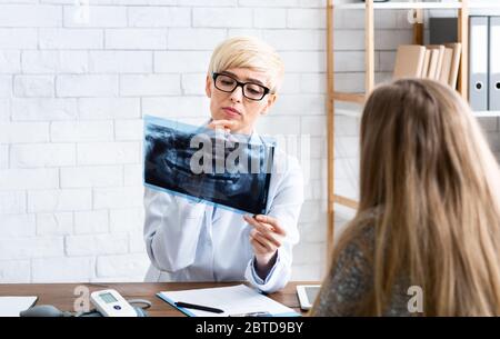 Zahnärztin untersucht Röntgenaufnahmen von Patienten im Inneren des Büros Stockfoto