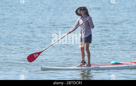 Southampton, Hampshire, Großbritannien. Mai 2020. Wetter in Großbritannien. Zwei Damen paddeln auf dem Solent mit der Isle of Wight im Hintergrund an einem heißen Feiertagsmontagmorgen in Calshot Beach. Credit Stuart Martin/Alamy Live News Stockfoto