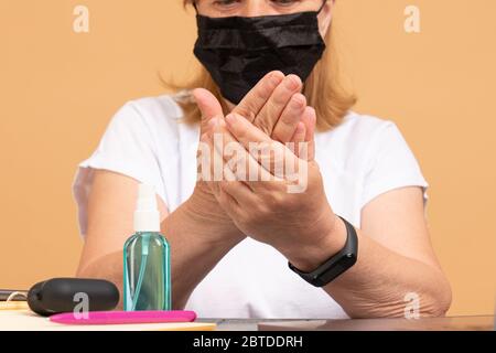 Frau, die Händedesinfektionsmittel auf den Händen verwendet. Die Wirkung von Reiben Handdesinfektionsmittel auf beiden Händen. Bedeutung der Händedesinfektionsmittel Stockfoto