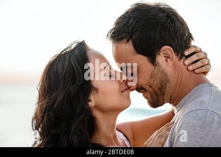 Liebevolles Paar mit geschlossenen Augen am Strand Stockfoto