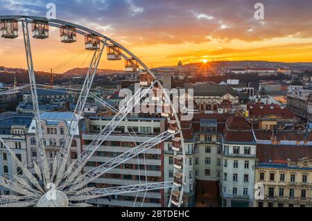 Budapest, Hungary - Luftaufnahme des berühmten Riesenrads von Budapest mit dem Budaer Schloss Königspalast und einem erstaunlichen goldenen Sonnenuntergang und Himmel auf dem Rücken Stockfoto