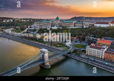 Budapest, Ungarn - Blick auf die völlig leere Szechenyi-Kettenbrücke mit Clark Adam Platz, Buda Castle Royal Palace und farbenfroher Sonnenuntergang im Backgr Stockfoto