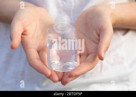 Eine echte junge Frau reinigt ihre Hände mit hydroalkoholischem Gel als Präventionsmethode, um zu vermeiden, COVID-19 auf andere Menschen in Madrid zu verbreiten. Stockfoto