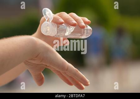 Eine echte junge Frau reinigt ihre Hände mit hydroalkoholischem Gel als Präventionsmethode, um zu vermeiden, COVID-19 auf andere Menschen in Madrid zu verbreiten. Stockfoto