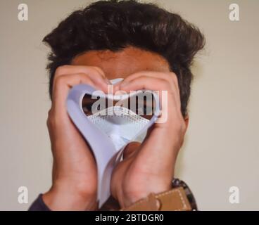 Mann suchen gerade Kamera aus gefalteten Papierrolle. Stilvolle Look des Menschen. Stockfoto