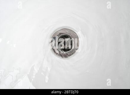 Wasser fließt in das Waschbecken im Badezimmer. Stockfoto