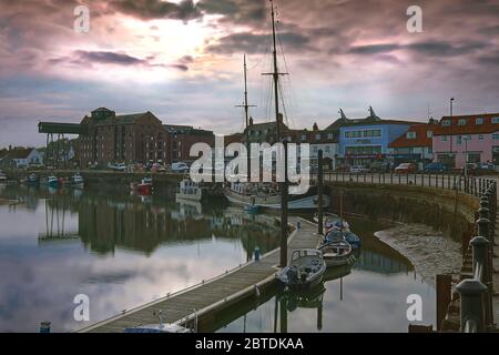 Der Himmel bei Sonnenaufgang spiegelte sich im Wasser des Hafens von Wells-next-the-Sea, Norfolk, Großbritannien Stockfoto