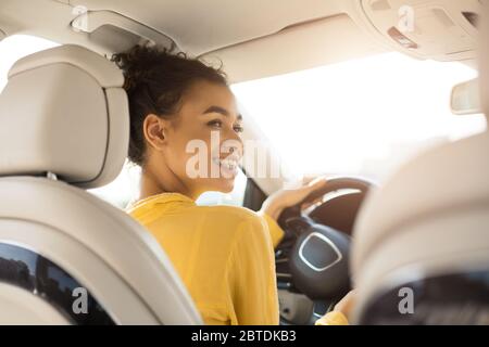 Fröhliche Schwarze Frau Auto Fahren Im Automobil Sitzen, Rückansicht Stockfoto