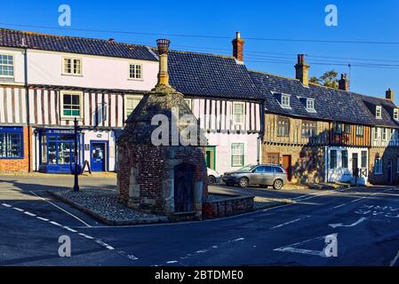 The Pump at Common Place, Little Walsingham, Norfolk, Großbritannien. Das alte Dorfpumpenhaus für das Wasserziehen umgeben von Fachwerkhäusern Stockfoto