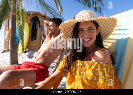 Kaukasisches Paar auf Liegestühlen am Strand Stockfoto