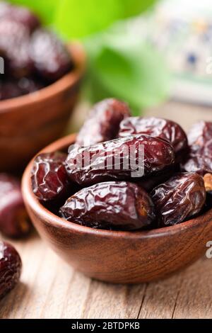 getrocknete medjool Datteln in Schale auf Holztisch Hintergrund. Arabisch-Östliche Küche Stockfoto