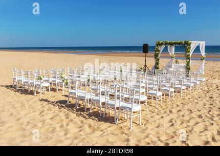 Romantische Aussicht und Blumendekoration am Strand in der Nähe des Meeres, für eine Hochzeitszeremonie mit Blumen. Europa, Portugal. Stockfoto