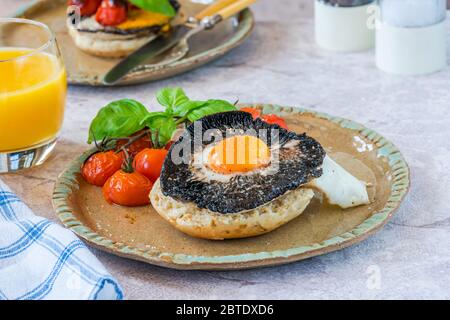 Brunch mit gebackenen Eiern und Pilzen mit Baby-Tomaten Stockfoto