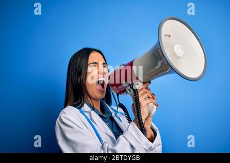 Hispanische Ärztin mit medizinischem weißen Mantel schreiend wütend auf Protest durch Megaphon. Schreien aufgeregt auf Ludspeaker reden und schreiende Nachrichten Stockfoto