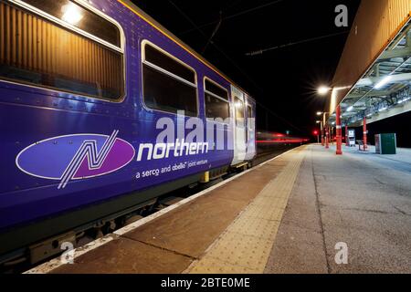 Serco Abellio Northern Rail Logo auf einem Zug der Klasse 153 mit leichten Spuren von einem anderen abfahrenden Zug. Stockfoto