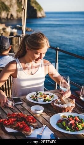 Junge Frau, die in einem Café im Freien in Italien zu Abend gegessen hat Stockfoto