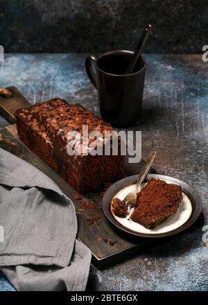 Teller mit Scheibe schmackhafter hausgemachter Schokoladenkuchen auf rustikalem Hintergrund. Dunkle Lebensmittel Fotografie. Selektiver Fokus. Stockfoto