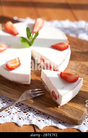 Scheibe Erdbeerkäsekuchen auf weißem Hintergrund, selektiver Fokus, quadratisches Bild. Stockfoto