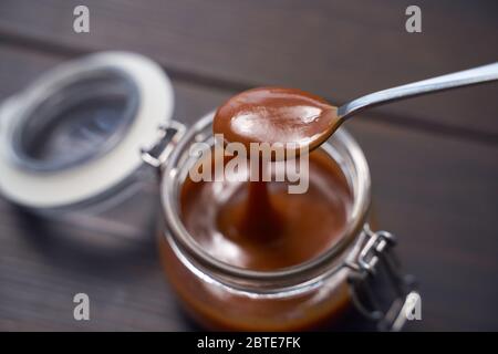 Auf einem Holztisch mit Salz geschmolzenes Karamell. Stockfoto