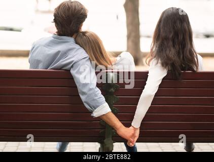 Freund hält Hände mit Freundin Freund sitzt auf Bank im Freien Stockfoto