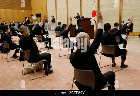 Tokio, JAPAN. Mai 2020. Journalisten, die auf ihren Sitzen soziale Distanz wahren, heben die Hände, um Japans Premierminister Shinzo Abe auf einer Pressekonferenz über Japans Reaktion auf die Coronavirus-Krankheit (COVID-19) am 25. Mai 2020 in Tokio, Japan, Fragen zu stellen. Kredit: POOL/ZUMA Wire/Alamy Live News Stockfoto