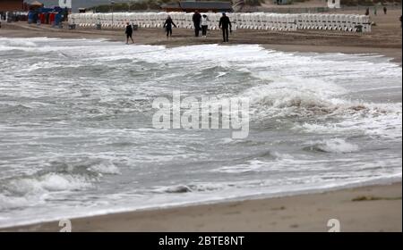 25. Mai 2020, Mecklenburg-Vorpommern, Warnemünde: Wind und Wolken sorgen für graues, schmutziges Wetter an der Ostsee laufen nur wenige Menschen am Strand. Foto: Bernd Wüstneck/dpa-Zentralbild/dpa Stockfoto