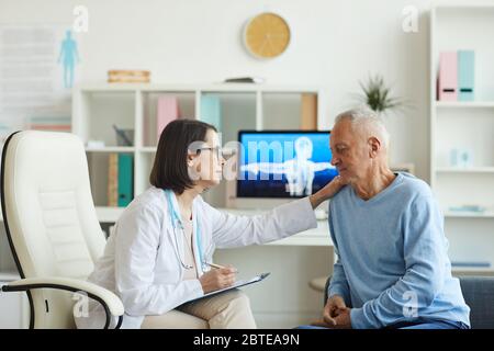 Seitenansicht Porträt der fürsorglichen weiblichen Arzt trösten Senior Patient während der Konsultation in der Klinik, kopieren Raum Stockfoto