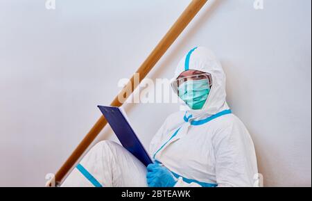 Containment Scout mit Checkliste für Kontaktverfolgung auf Treppen von zu Hause oder Klinik bei Coronavirus-Pandemie Stockfoto