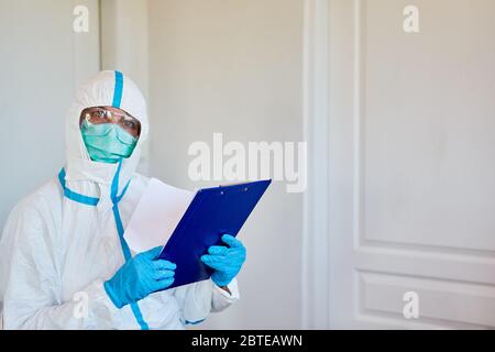 Containment Scout des Gesundheitsministeriums in Schutzkleidung mit Checkliste zur Kontaktverfolgung im Falle einer Coronavirus-Pandemie Stockfoto