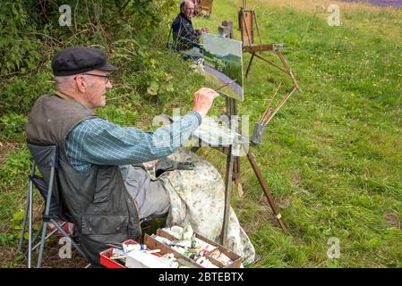 Shoreham,Kent,UK - Juli 16 2017 :Künstler sitzen neben einem Lavendelfeld in Kent,UK Malerei die Szene vor ihnen Stockfoto