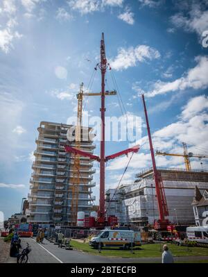 Ein massiver Kran, der einen großen Kran auf einer Baustelle demontiert. Stockfoto