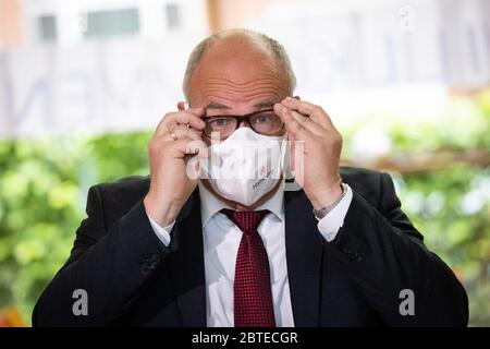 Hamburg, Deutschland. Mai 2020. Ties Rabe (SPD), Senator für Schule und Berufsbildung in Hamburg, legt bei einer Fotosession in der Grundschule Wielandstraße seine Mundnasenhülle mit dem Hamburger Logo auf. Nach drei Monaten Urlaub und Online-Unterricht sollen alle Hamburger Schüler diese Woche wieder ihre Lehrer besuchen. Am Montag nahm Rabe die ersten Masken einer Spende von insgesamt 50,000 Masken der Online-Versandfirma About You an der Grundschule im Kreis Eilbek entgegen. Kredit: Christian Charisius/dpa/Alamy Live News Stockfoto