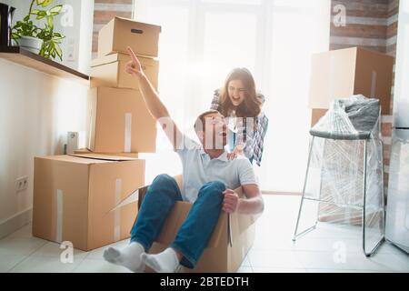Glückliches Paar ist Spaß mit Kartons in neues Haus bei sich bewegenden Tag. Stockfoto