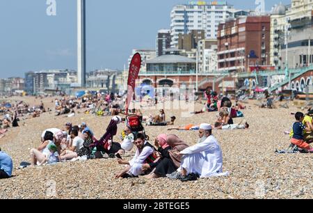 Brighton UK 25. Mai 2020 - Besucher genießen den Feiertagshitzigen Sonnenschein am Brighton Strand heute, da die Temperaturen während der Coronavirus COVID-19 Pandemie-Krise die hohen 20er Jahre im Südosten Englands erreichen werden. Quelle: Simon Dack / Alamy Live News Stockfoto