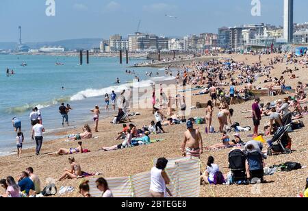 Brighton UK 25. Mai 2020 - Besucher genießen den Feiertagshitzigen Sonnenschein am Brighton Strand heute, da die Temperaturen während der Coronavirus COVID-19 Pandemie-Krise die hohen 20er Jahre im Südosten Englands erreichen werden. Quelle: Simon Dack / Alamy Live News Stockfoto