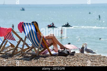 Brighton UK 25. Mai 2020 - Besucher genießen den Feiertagshitzigen Sonnenschein am Brighton Strand heute, da die Temperaturen während der Coronavirus COVID-19 Pandemie-Krise die hohen 20er Jahre im Südosten Englands erreichen werden. Quelle: Simon Dack / Alamy Live News Stockfoto