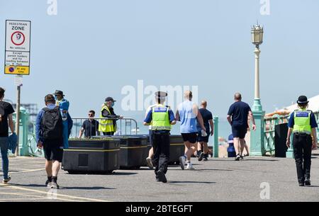 Brighton UK 25. Mai 2020 - Besucher genießen den Feiertagshitzigen Sonnenschein am Brighton Strand heute, da die Temperaturen während der Coronavirus COVID-19 Pandemie-Krise die hohen 20er Jahre im Südosten Englands erreichen werden. Quelle: Simon Dack / Alamy Live News Stockfoto