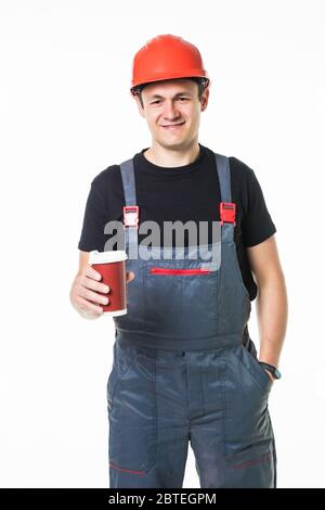 Nahaufnahme der glückliche Arbeiter in harten Hut holding Pappbecher mit Kaffee zu gehen und ein Lächeln auf die Kamera isoliert auf weißem Stockfoto