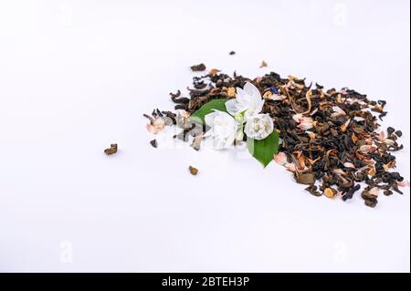Jasmintee in einem Glas auf weißem Hintergrund. Weiße Blüten mit Blättern und getrocknetem Tee zum Brühen und für ein duftendes Getränk. Aromatherapie und Wellness. Freier Platz für Text. Kopierbereich. Stockfoto
