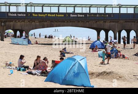 Die Menschen genießen das heiße Wetter am Strand von Boscombe in Dorset, nachdem Maßnahmen eingeführt wurden, um das Land aus der Blockierung zu bringen. Stockfoto