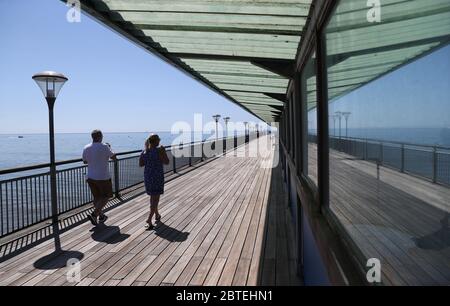 Die Menschen laufen entlang der Boscombe Pier in Dorset, nach der Einführung von Maßnahmen, um das Land aus der Blockierung zu bringen. Stockfoto