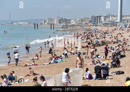Brighton UK 25. Mai 2020 - Besucher genießen den Feiertagshitzigen Sonnenschein am Brighton Strand heute, da die Temperaturen während der Coronavirus COVID-19 Pandemie-Krise die hohen 20er Jahre im Südosten Englands erreichen werden. Quelle: Simon Dack / Alamy Live News Stockfoto