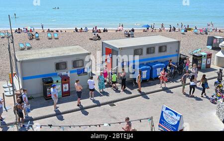 Brighton UK 25. Mai 2020 - Besucher stellen sich für die öffentlichen Toiletten an, während sie den Feiertagshitzigen Sonnenschein am Brighton Strand genießen, da die Temperaturen während der Coronavirus COVID-19 Pandemie-Krise die hohen 20er Jahre im Südosten Englands erreichen werden. Quelle: Simon Dack / Alamy Live News Stockfoto