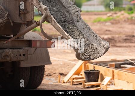 Verlegung des Zements oder Betons in die Fundamentschalung mit automatischer Pumpe. Gebäude Haus Fundament Stockfoto