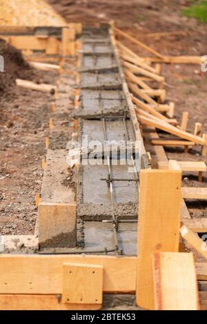 Verlegung des Zements oder Betons in die Fundamentschalung mit automatischer Pumpe. Gebäude Haus Fundament Stockfoto