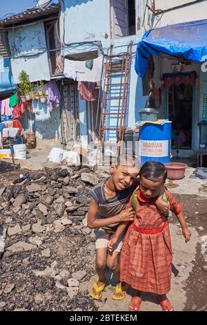 Mädchen Kinder in einem Slum-Bereich in Mumbai, Indien, lächelnd und verspielt trotz der schrecklichen Umgebung Stockfoto